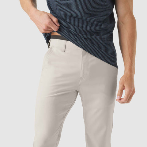 Jetsetter Tech Pant Slim Fit in beige, featuring wrinkle-free and anti-odor fabric, worn by a person.