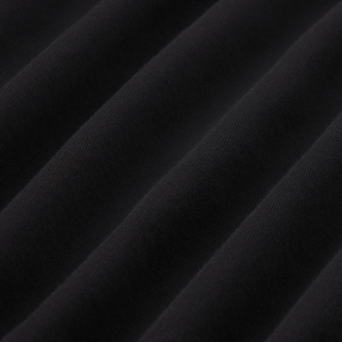 Close-up of black organic cotton fabric from Precision Long Sleeve Tee showcasing soft, wrinkle-resistant texture.