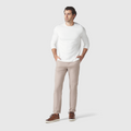 Slim fit man wearing beige Jetsetter Tech Pant with white top and brown shoes.