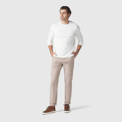 Slim fit man wearing beige Jetsetter Tech Pant with white top and brown shoes.