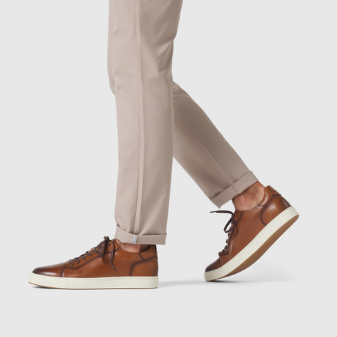 Slim fit Jetsetter Tech Pant in beige, wrinkle-free microfiber fabric, paired with brown leather sneakers.