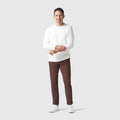 Man wearing Jetsetter Tech Pant Slim Fit in brown, demonstrating travel-friendly and wrinkle-free features.