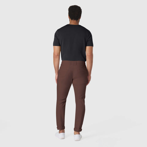 Man wearing Jetsetter Tech Pant Slim Fit in brown, showcasing travel-friendly, wrinkle-free style.