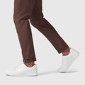 Jetsetter Tech Pant Slim Fit with wrinkle-free, stain-repellent microfiber fabric, shown in brown, worn with white sneakers.