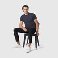 Jetsetter Tech Pant Slim Fit in black worn by a seated model, showcasing comfort and style.