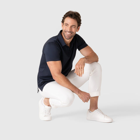 Jetsetter Tech Pant Slim Fit in white, perfect for travel with anti-odor, wrinkle-free, and stain repellent features, worn by a man in a casual pose.