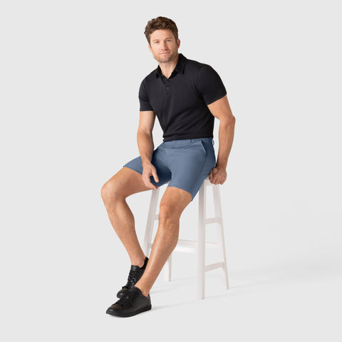 Male model wearing Jetsetter Tech Short in a seated pose, showcasing durable, flattering fit.