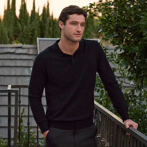 Man wearing Legacy Polo Sweater in black, standing outdoors.