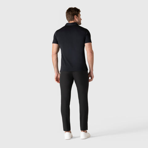 Man wearing Jetsetter Tech Pant Slim Fit in black, featuring comfort and wrinkle-free technology, rear view.