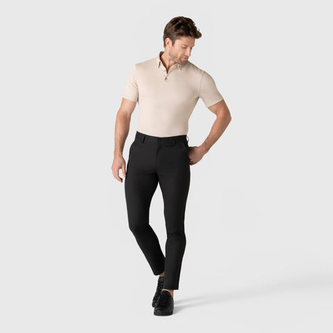 Man wearing Jetsetter Tech Pant Slim Fit in black, showcasing wrinkle-free, stain repellent fabric.