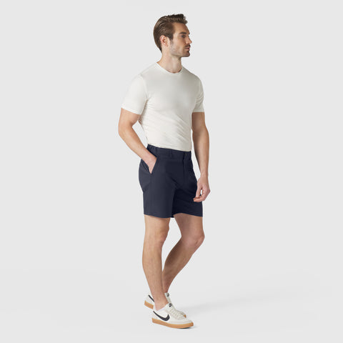 Man wearing navy Jetsetter Tech Short with a white t-shirt and sneakers.